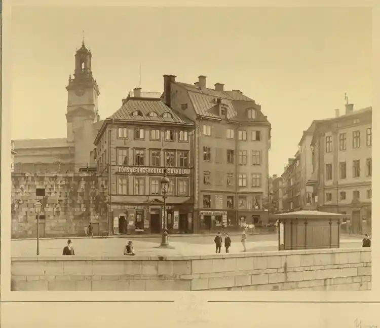Mynttorget 1, Försäkringsbolaget Skandias hus. Västerlånggatan t.h. I fonden Storkyrkans torn. De två husen vid Myntgatan 1 är numera ersatt av ett hus byggt 1886.