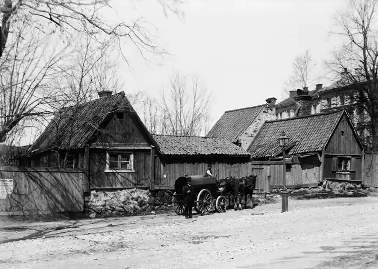 Ett hästfordon lastat med en tank står utanför Västra Humlegårdsgatan 27, kv. Eriksberg. Ungefär vid nuvarande Engelbreksgatan 25 och Runebergsplan