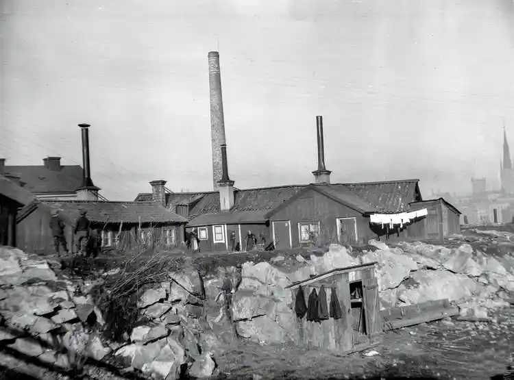 Östra Kvarngränd 6 och 4. Från Kungsholms Kyrkoplan ledde Östra Kvarngränd norrut. Husen ägdes av Bolinders AB och Bolinders fabriksskorsten ses i öster bakom taken. Nu Kungsklippan, kv. Stadsarkivet.