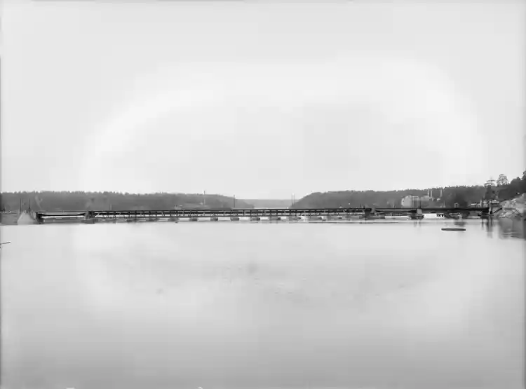 Gamla Tranebergsbron mot sydväst med Stora Essingen och Alvik i bakgrunden. Till höger bortom bron skymtar Lars Montén & Co:s stearinljusfabrik vid Alviks strand.