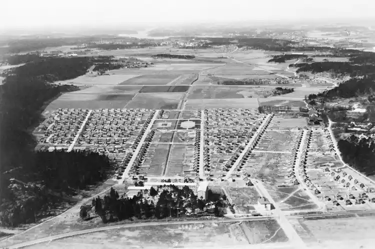 Flygvy mot nordväst över Enskede- och  Årstafältet med Östberga, Västberga, Midsommarkransen, Aspudden och Årsta i fonden.  Till höger syns Enskede gård.